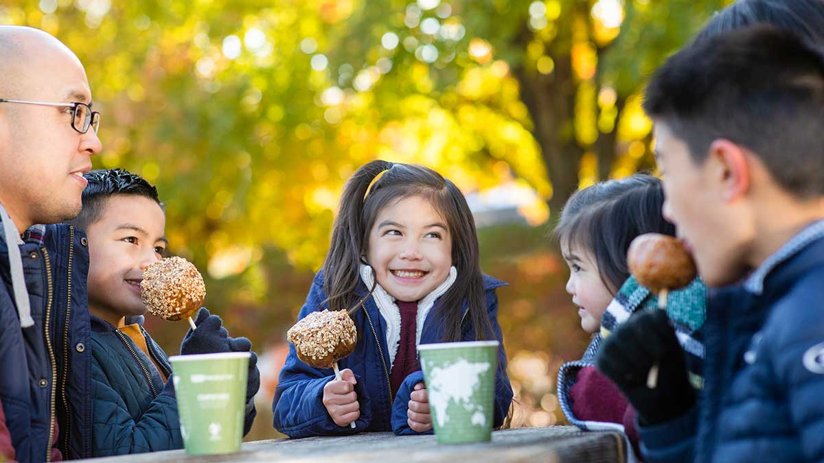 Family enjoying caramel apples during the fall