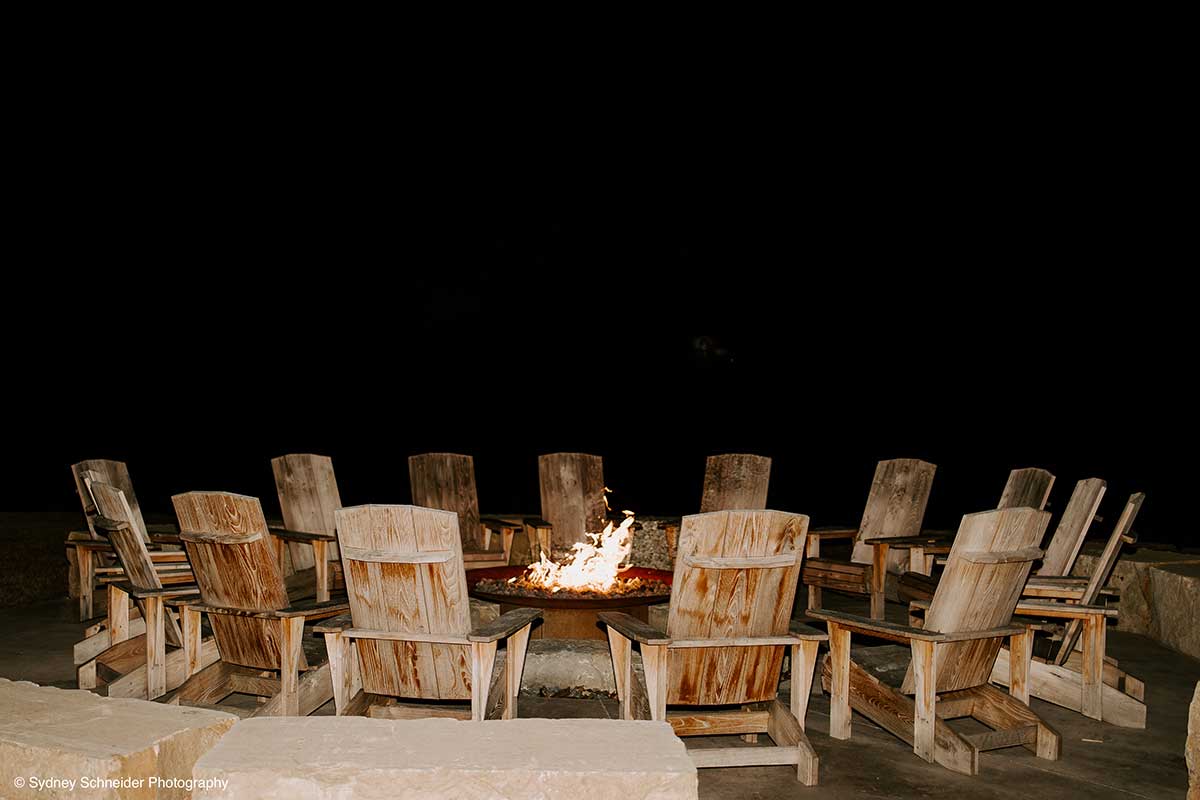 A Bunch of Wooden Chairs Surround a Firepit