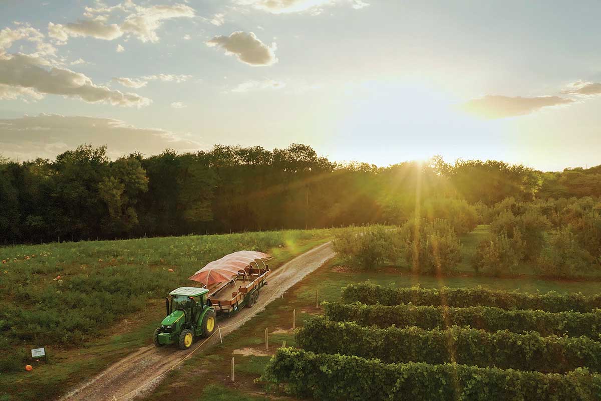 A tractor at Arbor Day Farm riding through the sunset