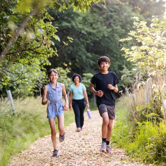 A family walking on a path outside in nature