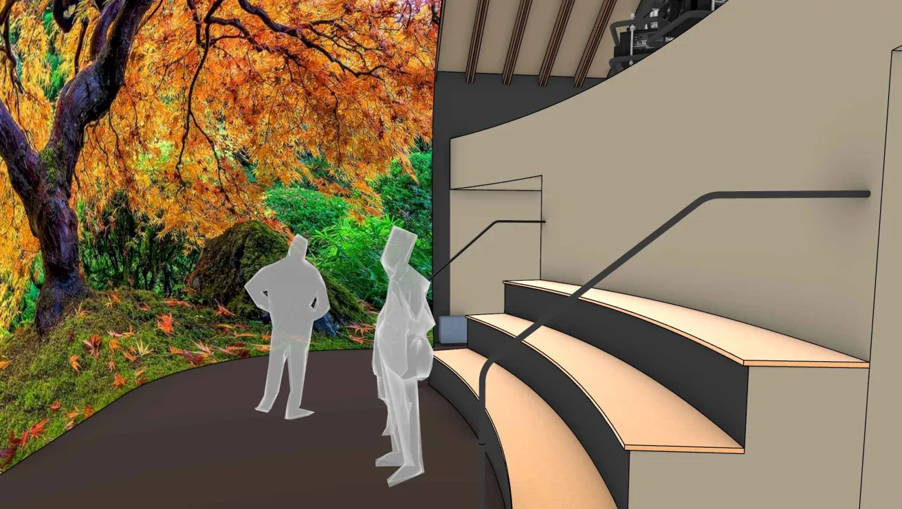 People viewing a large, vibrant autumn tree display in an indoor space with tiered seating and handrails.