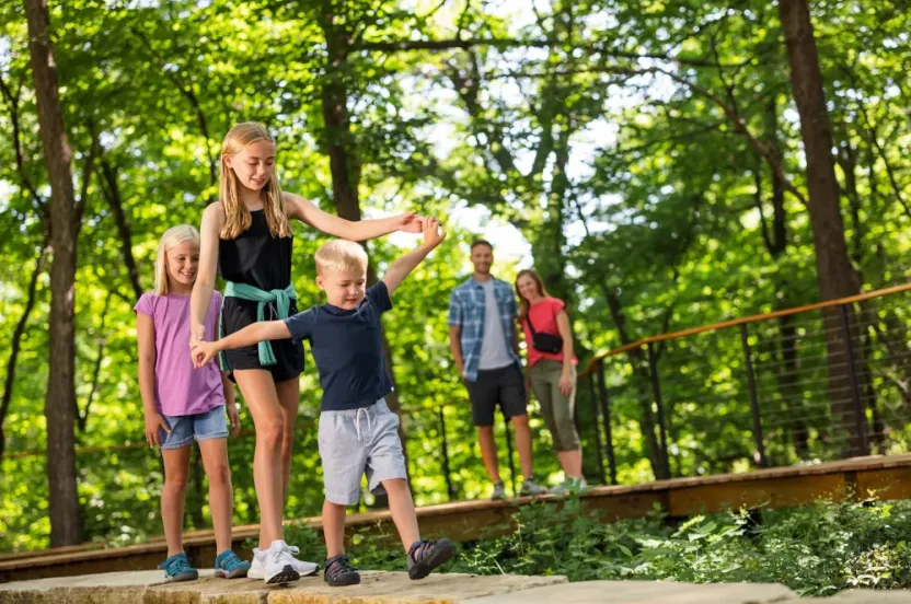 Kids playing outside surrounded by trees.